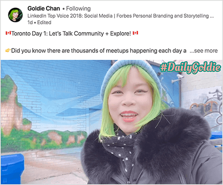 Αυτό είναι ένα στιγμιότυπο οθόνης ενός βίντεο στο LinkedIn στο οποίο η Goldie Chan τεκμηριώνει τα ταξίδια της. Το κείμενο πάνω από το βίντεο λέει "Τορόντο Ημέρα 1: Ας μιλήσουμε για την κοινότητα + Εξερεύνηση! Γνωρίζατε ότι υπάρχουν χιλιάδες συναντήσεις κάθε μέρα... δείτε περισσότερα". Το βίντεο δείχνει τη Γκόλντι μπροστά από μια τοιχογραφία σε έναν τοίχο από τούβλα. Η τοιχογραφία δείχνει έναν φωτεινό μπλε ουρανό και καφέ βράχια που καλύπτονται με έντονο πράσινο. Η Goldie εμφανίζεται από το στήθος προς τα πάνω. Είναι ασιατική γυναίκα με πράσινα μαλλιά. Φορά μπλε πλεκτό καπάκι και μαύρη ζακέτα με γούνινο γιακά. Στην επάνω δεξιά γωνία του βίντεο, το #DailyGoldie εμφανίζεται σε κείμενο ροδάκινου με πράσινο περίγραμμα.