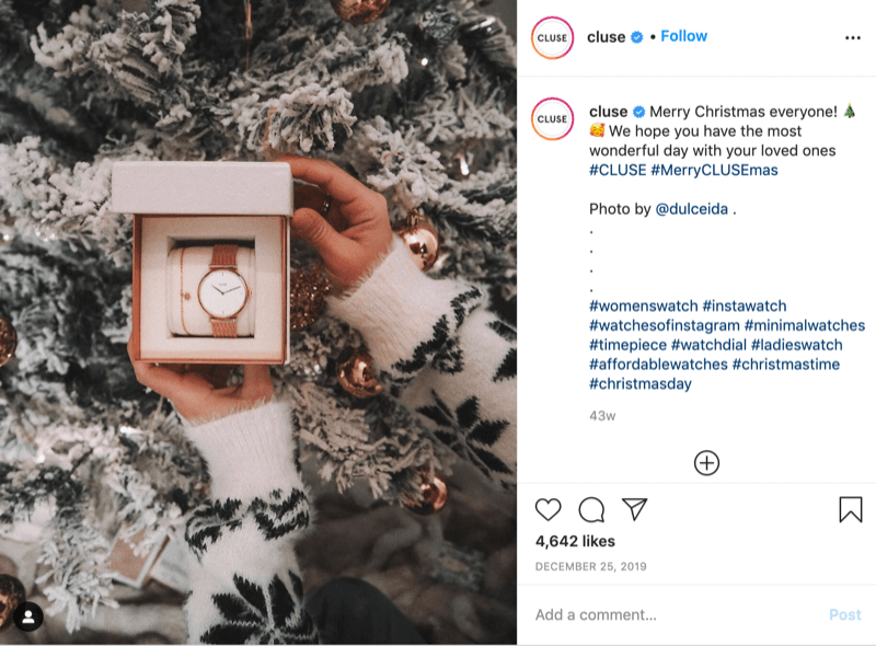 ανάρτηση instagram από το @cluse που δείχνει μια εικόνα ενός μοντέλου πουλόβερ με νιφάδα χιονιού που κρατά ένα ρολόι μπροστά από ένα χιονισμένο δέντρο από τον @dulceida με τα hashtags #cluse και #meryclusemas